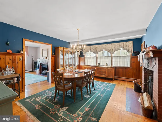 a dining room with wooden floor and chandelier