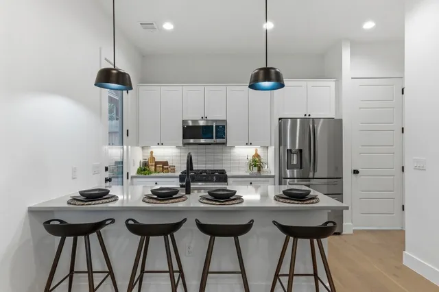 a kitchen with a dining table cabinets and appliances