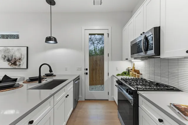 a kitchen with stainless steel appliances a sink a stove and a microwave