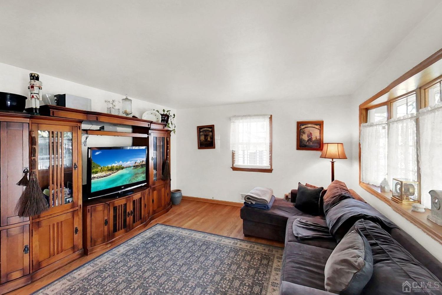 137 Kimberly Road Colonia, NJ 07067 - Photo 9 of 39 a living room with furniture a flat screen tv and a floor to ceiling window