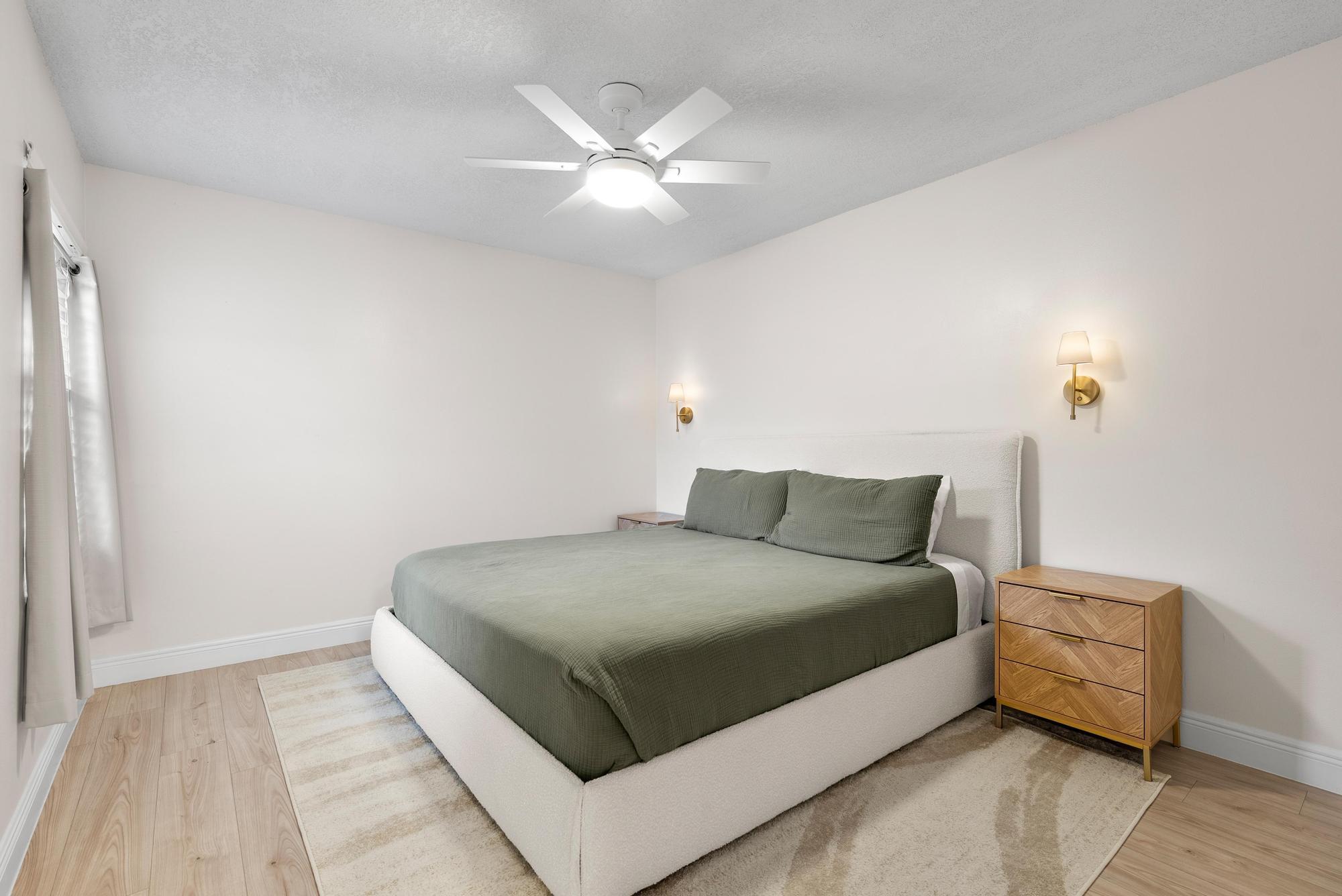 1219 Ocean Dunes Circle Jupiter, FL 33477 - Photo 19 of 35 a large bedroom with a bed and a chandelier