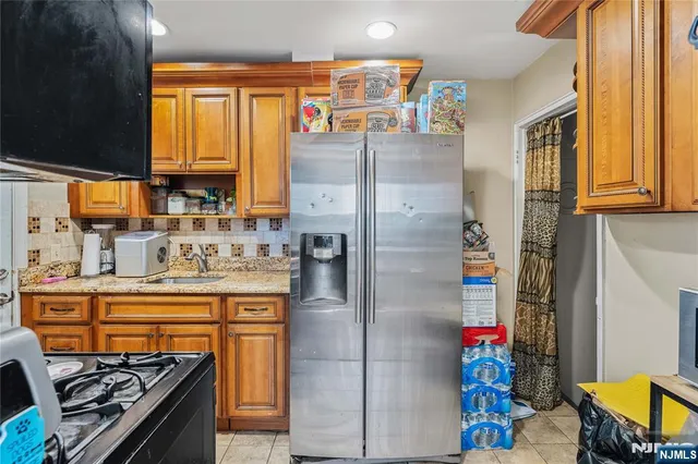 a kitchen with stainless steel appliances granite countertop a refrigerator and a stove