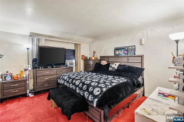 a bedroom with a bed and flat screen tv