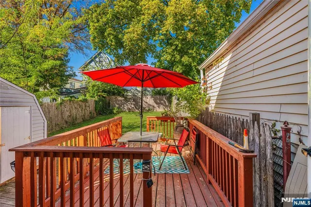 a balcony with wooden floor and umbrella