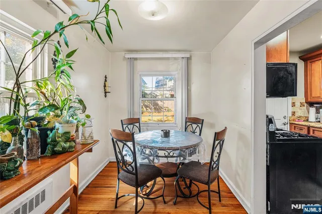 a dining room with furniture potted plants and wooden floor