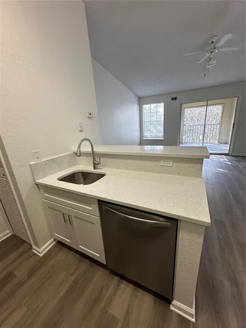 a view of a kitchen with a sink and wooden floor