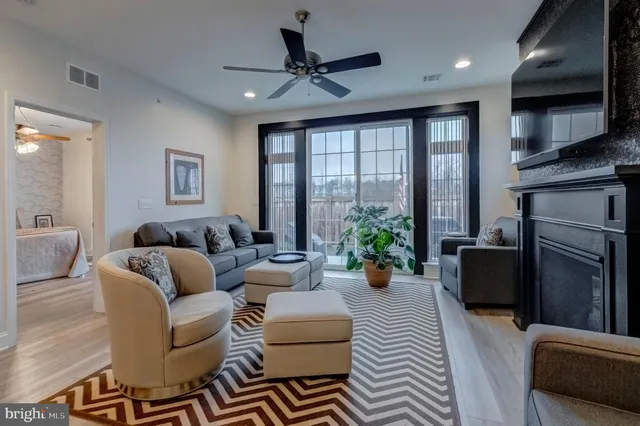 a living room with furniture fireplace and a large window