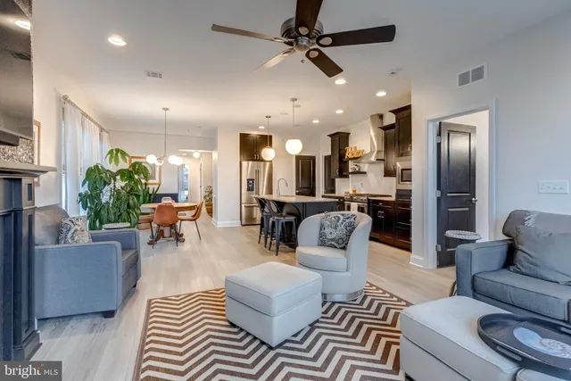 a living room with furniture and a view of kitchen
