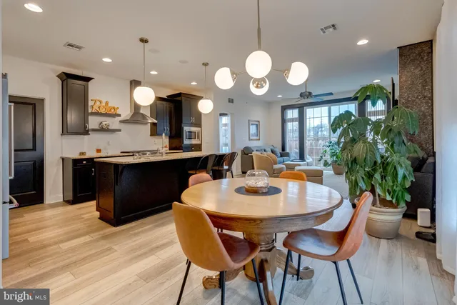 a kitchen with a dining table cabinets and stainless steel appliances