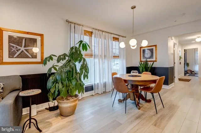 a dining room with furniture potted plants and wooden floor