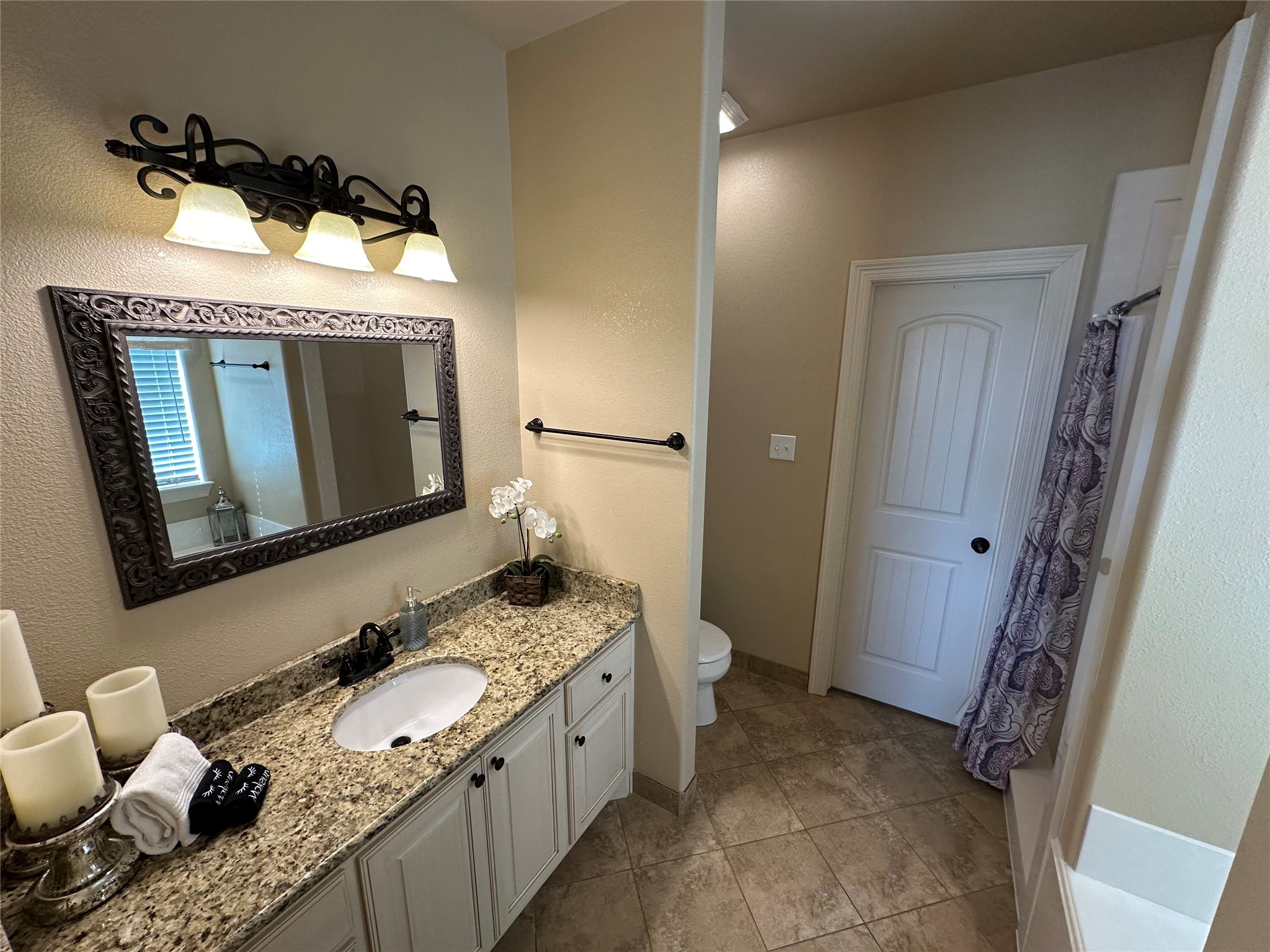 2029 Idyle View Crystal Beach, TX 77650 - Photo 30 of 36 a bathroom with a granite countertop sink mirror vanity and toilet