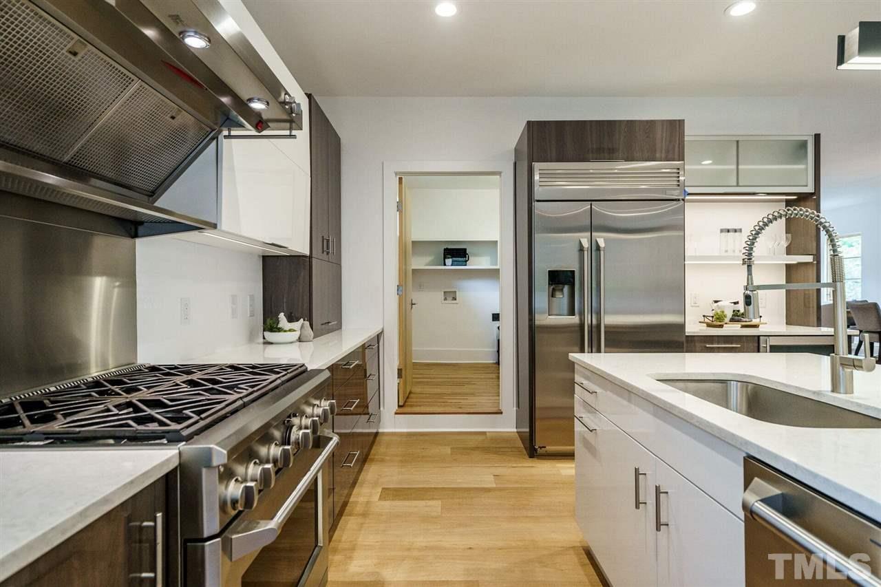 1619 Lorraine Road Raleigh, NC 27607 - Photo 12 of 30 Note the Stainless Steel Farmhouse Sink and the Appliance Cubby at the end of the counter beyond the Six-Burner Gas Range.