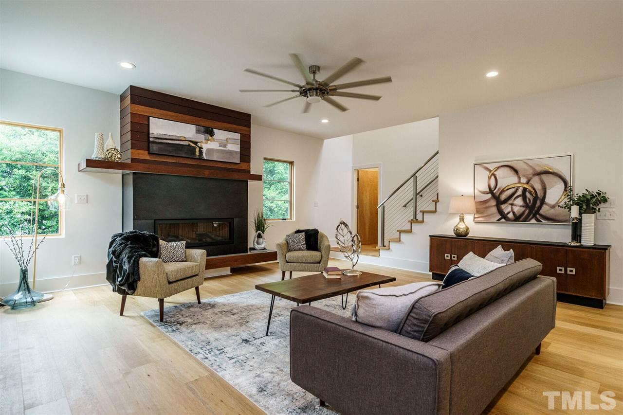 1619 Lorraine Road Raleigh, NC 27607 - Photo 6 of 30 Filled with Light, this Family Room is like a work of art. From the Custom Steel, Concrete, and Brazilian Teak 50k BTU Fireplace to the Stainless Steel Rails and Cables of the Stairway (solid White Oak treads). Door opens to Powder Room.