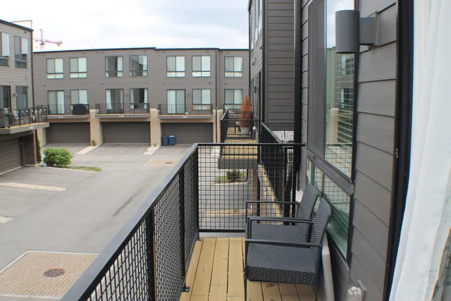 a view of balcony with two chairs and wooden fence