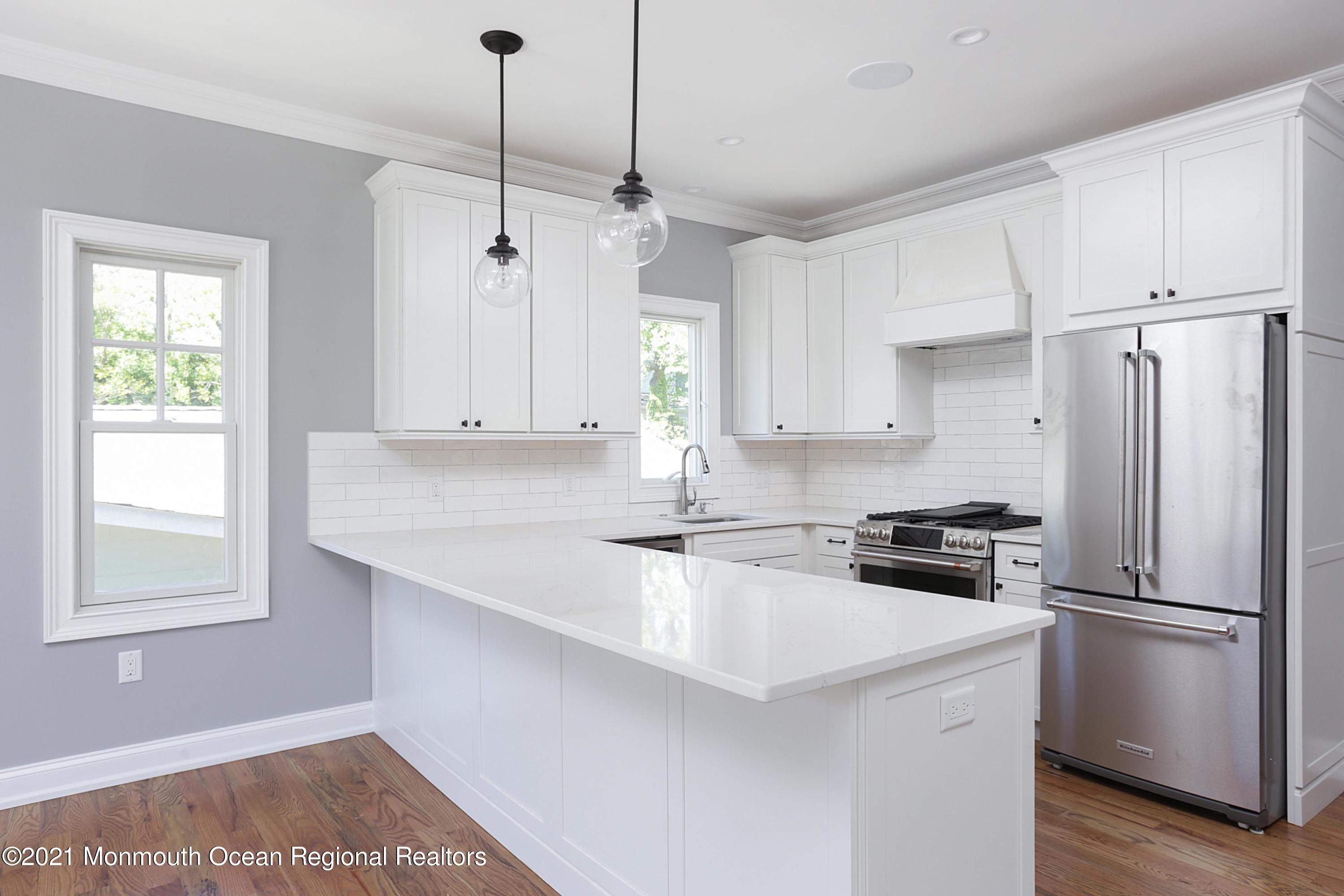 1 Meadowbrook Avenue Rumson, NJ 07760 - Photo 2 of 7 a kitchen with stainless steel appliances granite countertop a sink a stove a refrigerator and island with wooden floor