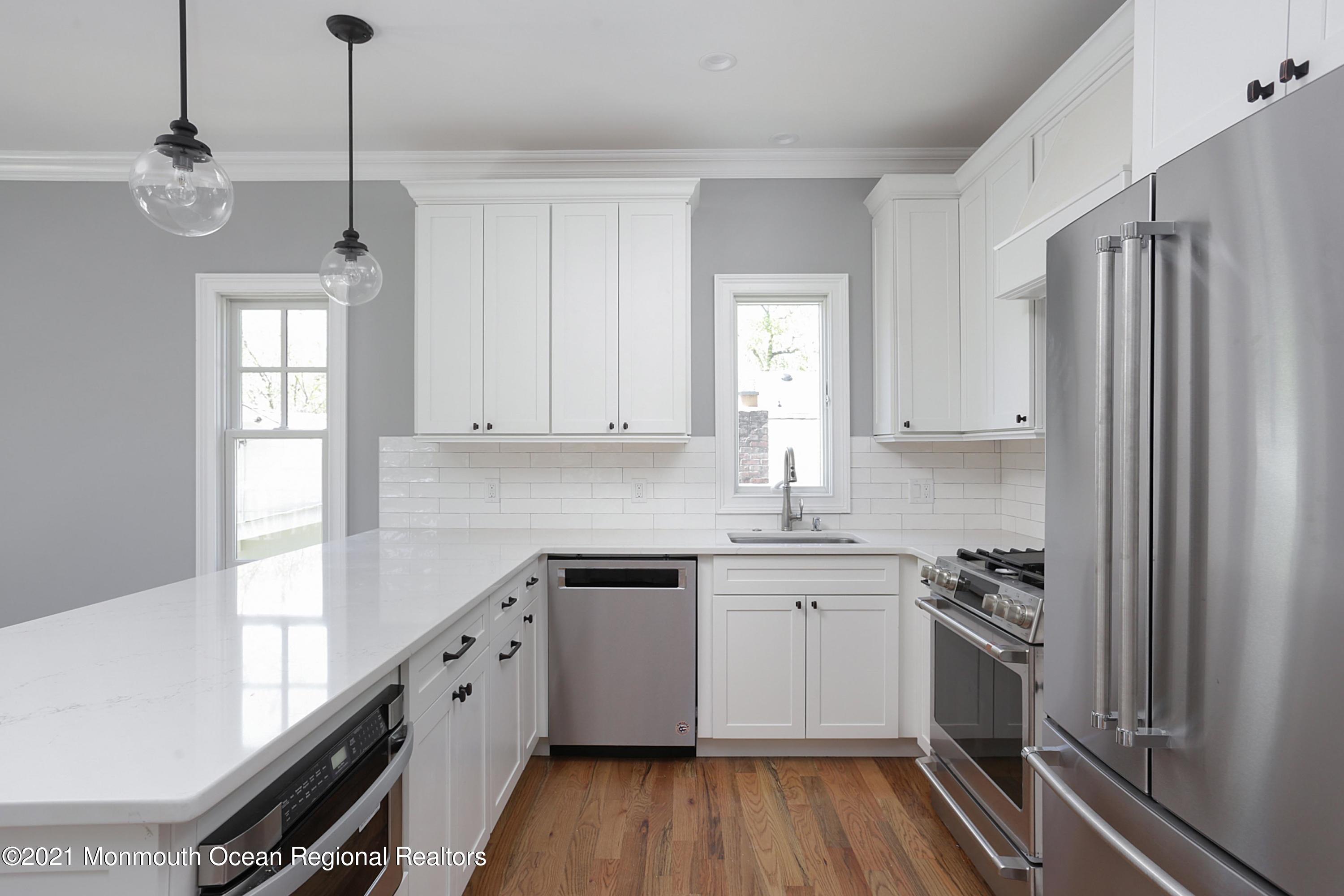 1 Meadowbrook Avenue Rumson, NJ 07760 - Photo 3 of 7 a kitchen with white cabinets and white appliances