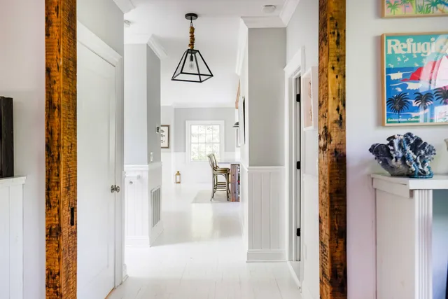 a view of a hallway with wooden floor and windows