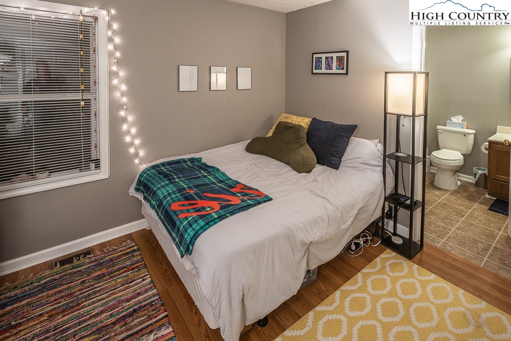 800 Meadowview Drive, Unit 6 Boone, NC 28607 - Photo 15 of 19 a bedroom with a bed and wooden floor