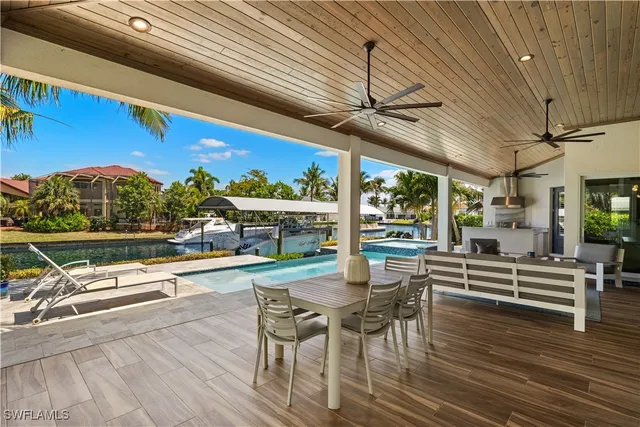 a view of a patio with dining table and chairs with wooden floor