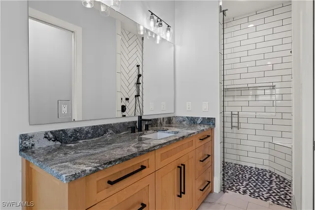 a bathroom with a granite countertop sink and a mirror