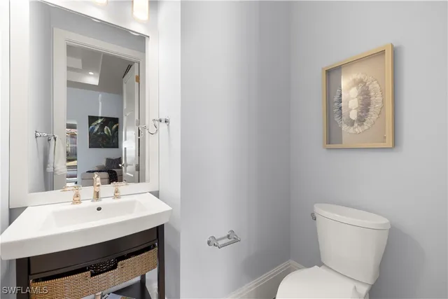 a bathroom with a toilet a sink and mirror