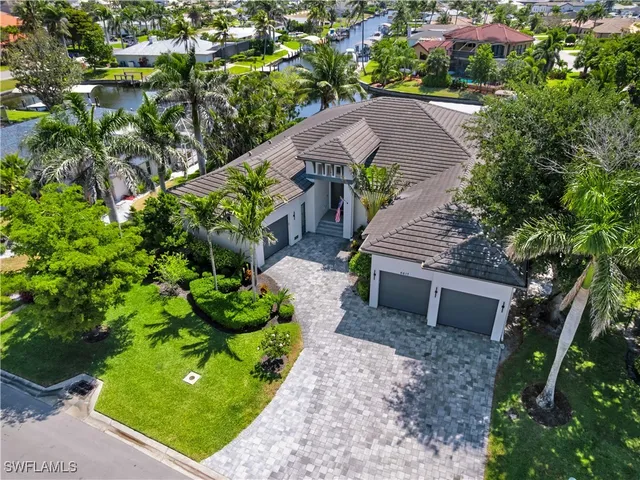 a aerial view of a house with a yard and large trees