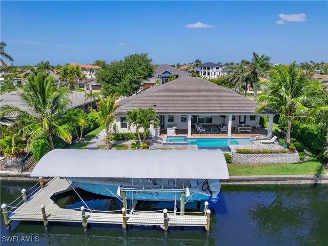 an aerial view of a house with swimming pool and outdoor seating