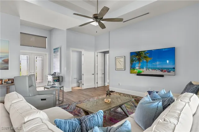 a living room with furniture a flat screen tv and kitchen view