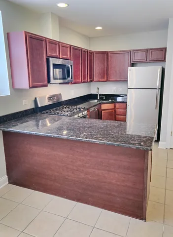 a kitchen with kitchen island granite countertop wooden cabinets a granite counter top and a stove top oven