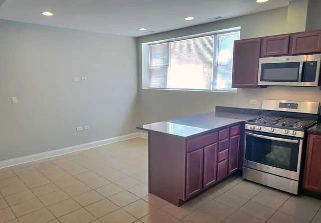 a kitchen with stainless steel appliances granite countertop a stove a microwave and a sink