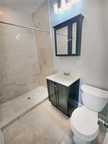 a bathroom with a sink toilet vanity and shower