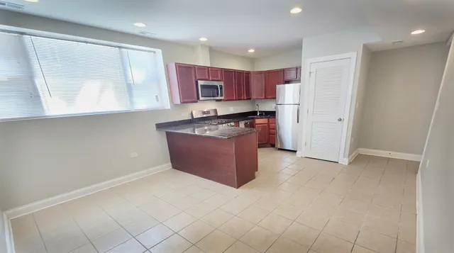 a kitchen with stainless steel appliances granite countertop a stove a sink and a refrigerator