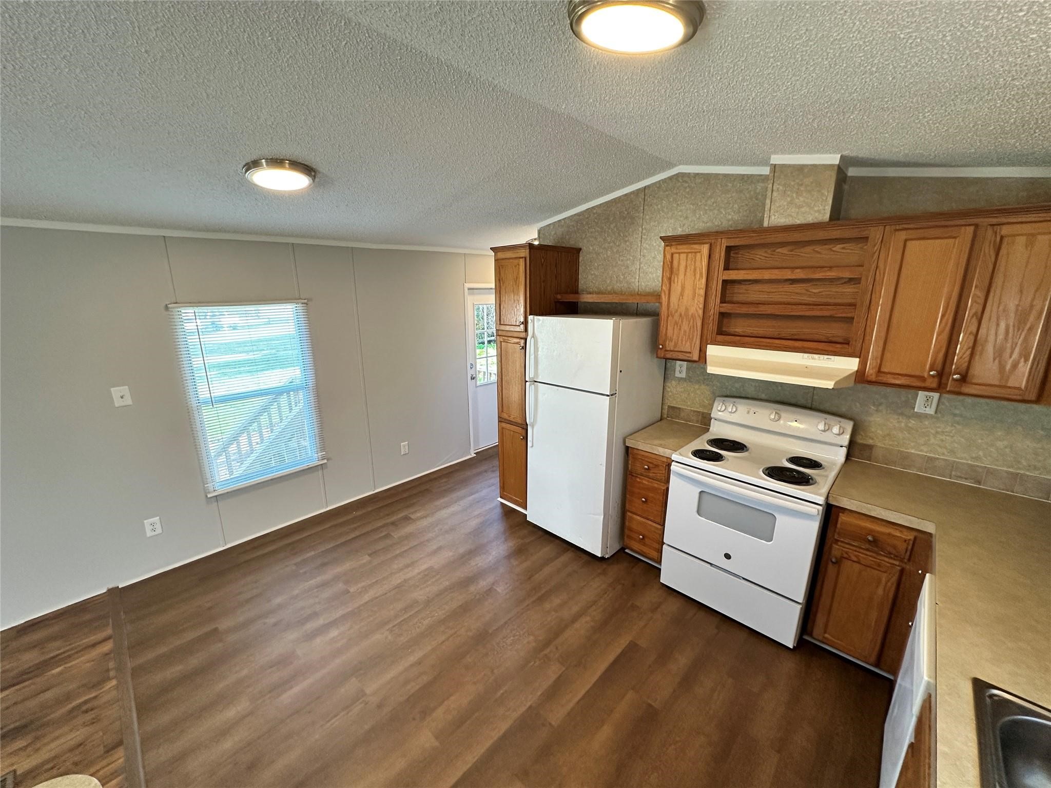 30841 Clyde Lane Hockley, TX 77447 - Photo 7 of 26 a kitchen with granite countertop a refrigerator a stove a sink dishwasher and white cabinets with wooden floor