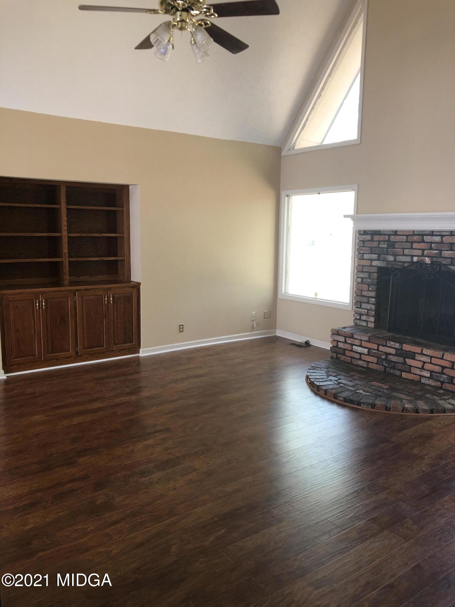 4980 Dixon Road Lizella, GA 31052 - Photo 4 of 10 an empty room with wooden floor and windows