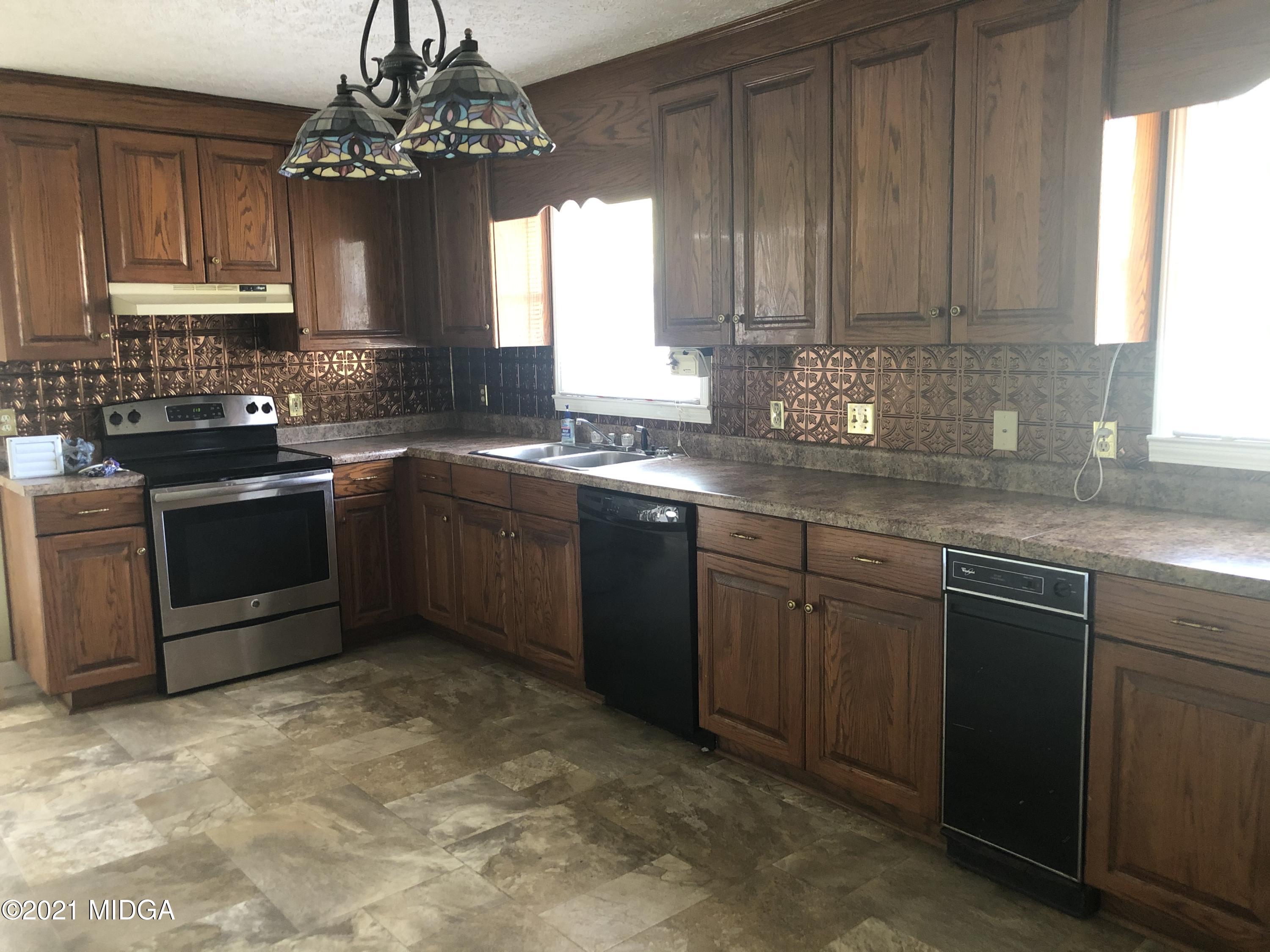 4980 Dixon Road Lizella, GA 31052 - Photo 5 of 10 a kitchen with stainless steel appliances granite countertop a sink dishwasher stove and cabinets