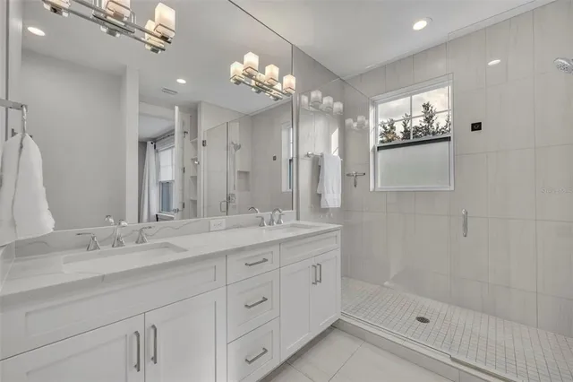 a bathroom with a double vanity sink mirror and shower