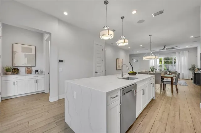 a large kitchen with lots of counter space a sink appliances and wooden floor