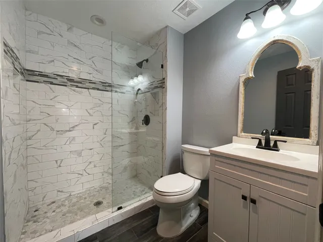 a bathroom with a sink a toilet and shower