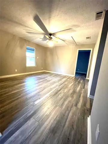 a view of a room with wooden floor and windows
