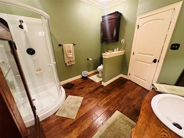 a bedroom with a bed a couch and a flat tv screen on the dresser