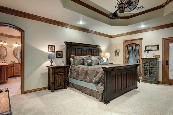 a bedroom with a bed and a flat tv screen on the dresser
