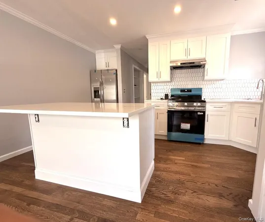 a kitchen with stainless steel appliances kitchen island granite countertop a stove top oven a sink and a refrigerator
