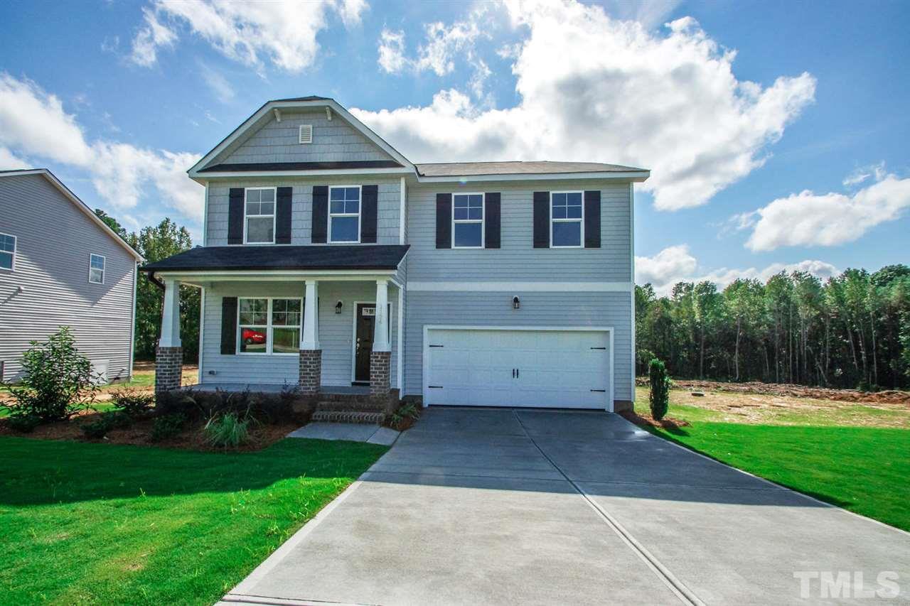 a front view of a house with a yard and trees