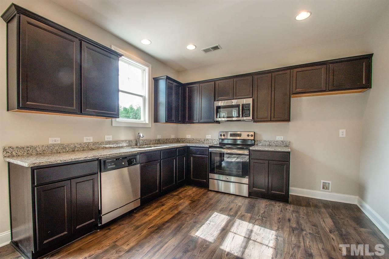 1124 Silver Farm Road Raleigh, NC 27603 - Photo 2 of 25 a kitchen with stainless steel appliances granite countertop a stove a sink and a microwave