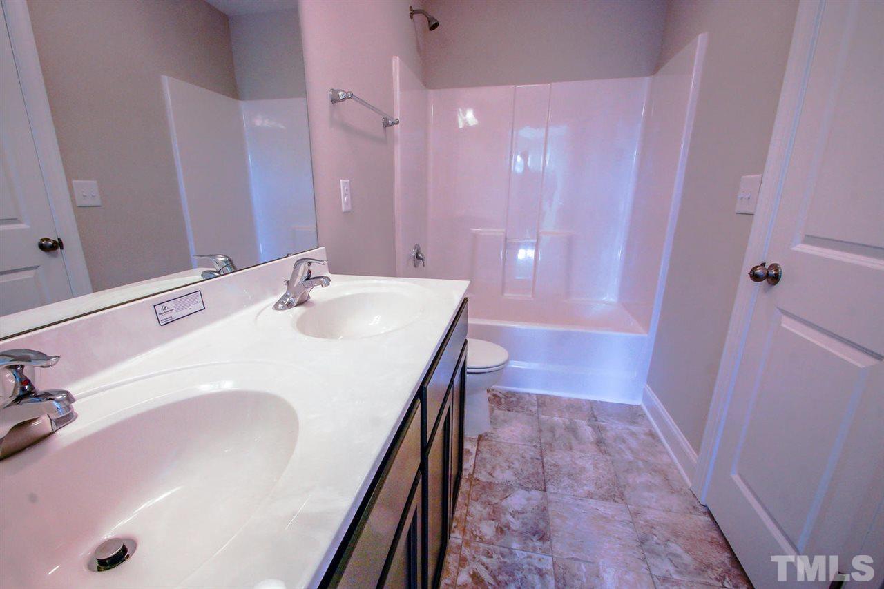 1124 Silver Farm Road Raleigh, NC 27603 - Photo 12 of 25 a bathroom with a sink a vanity and a mirror