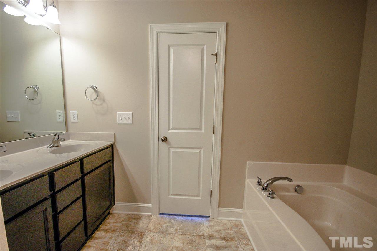 1124 Silver Farm Road Raleigh, NC 27603 - Photo 16 of 25 a bathroom with a tub sink and mirror