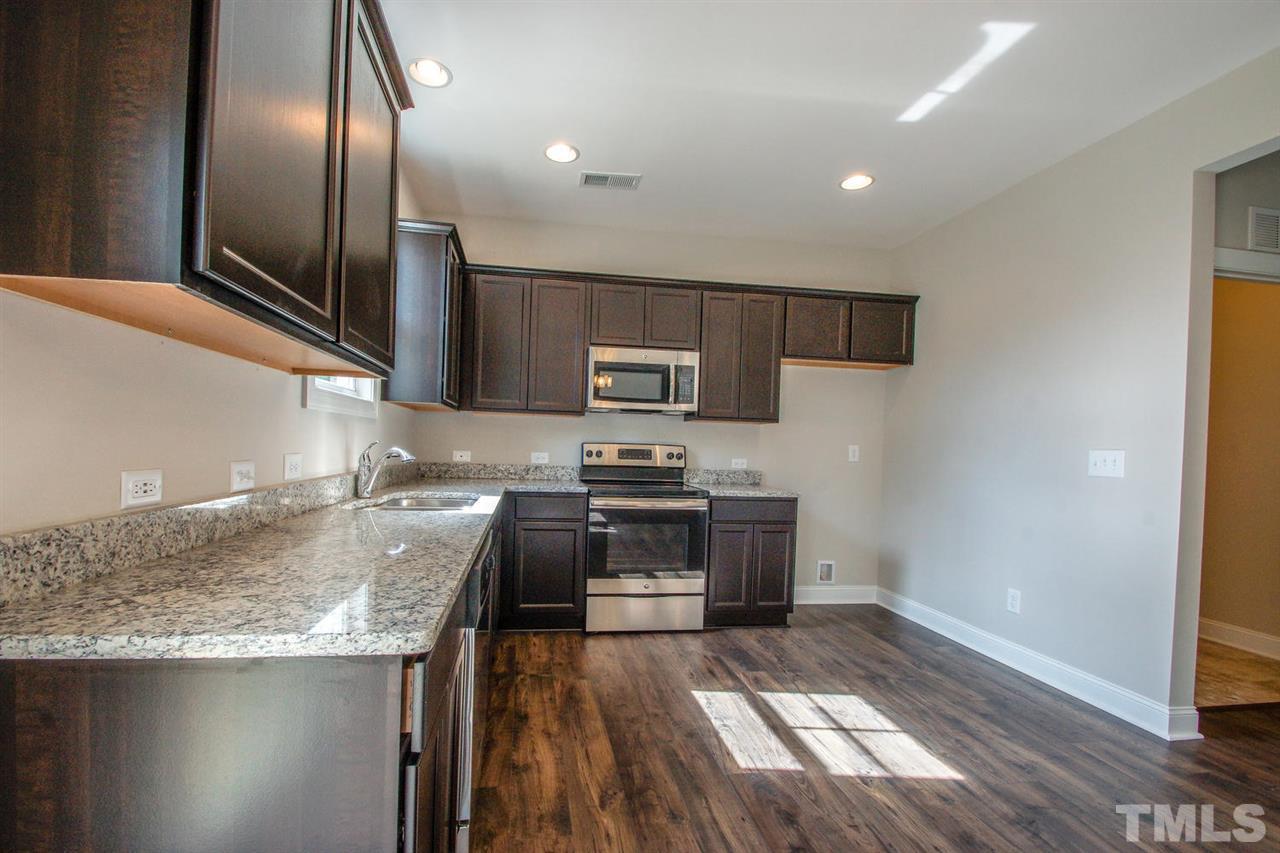 1124 Silver Farm Road Raleigh, NC 27603 - Photo 3 of 25 a kitchen with granite countertop stainless steel appliances and wooden cabinets