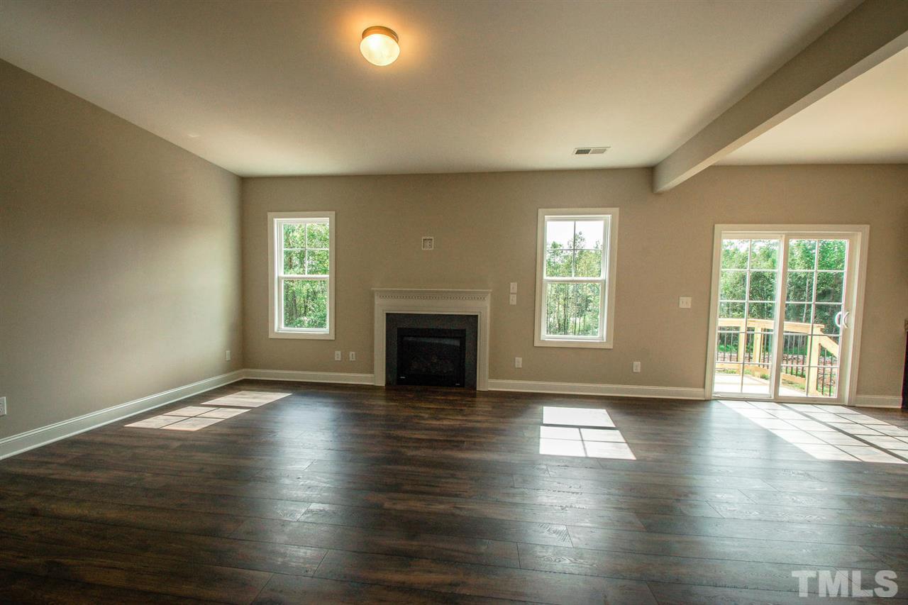 1124 Silver Farm Road Raleigh, NC 27603 - Photo 5 of 25 an empty room with wooden floor and windows