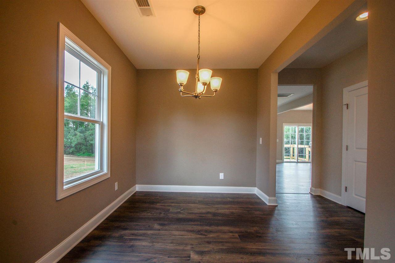 1124 Silver Farm Road Raleigh, NC 27603 - Photo 7 of 25 a view of a room with wooden floor chandelier and windows