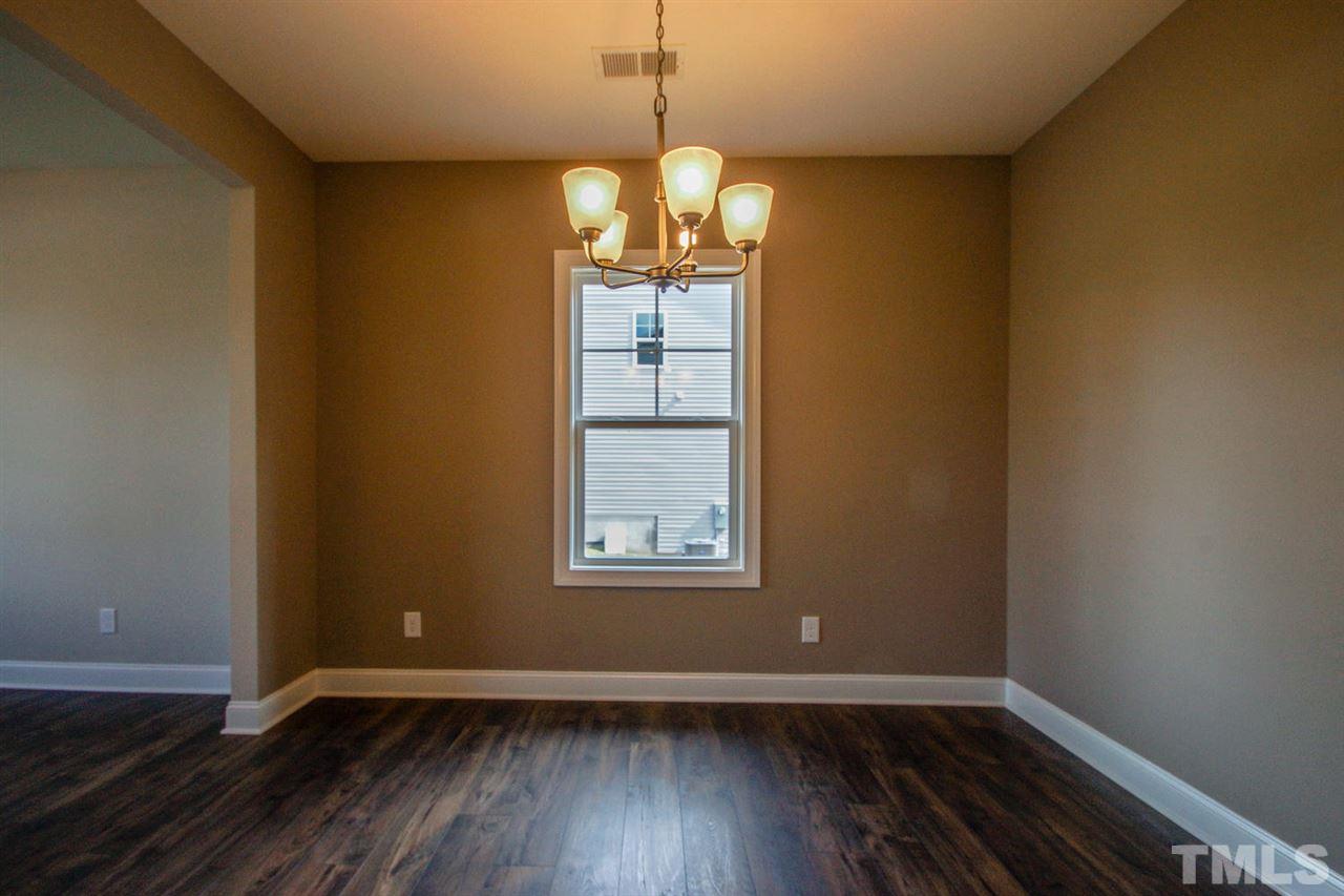 1124 Silver Farm Road Raleigh, NC 27603 - Photo 8 of 25 a view of an empty room with wooden floor and a window